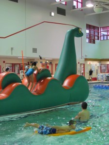 Kids at the library pool party test out the new inflatable, Nessy.