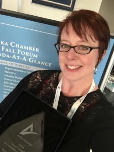 Cyni Crary holding the local chamber of the year award.